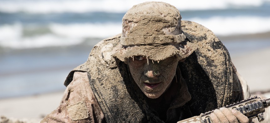 A scout swimmer with 1st Battalion, 5th Marines, I Marine Expeditionary Force, low crawls during a boat raid course at Red Beach, Camp Pendleton, California, Sept. 22, 2021.