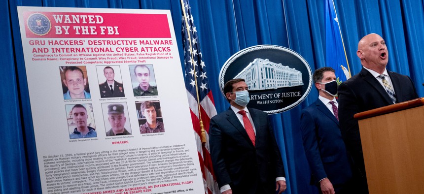A poster showing six wanted Russian military intelligence officers is displayed as federal officials announce indictments against six Russia intelligence officers in a hacking case in October, 2020. 