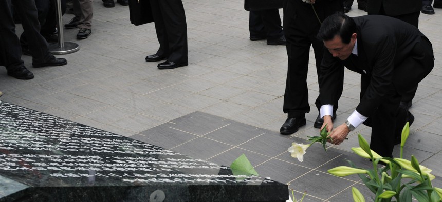 Taiwan's then-President Ma Ying-jeou places a flower in front of a monument during the 2009 commemoration of the anniversary of a massacre perpetrated by Kuomintang forces. 