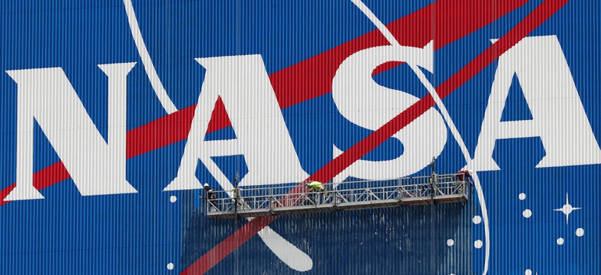 Workers repaint the NASA logo on the Vehicle Assembly Building at the Kennedy Space Center.